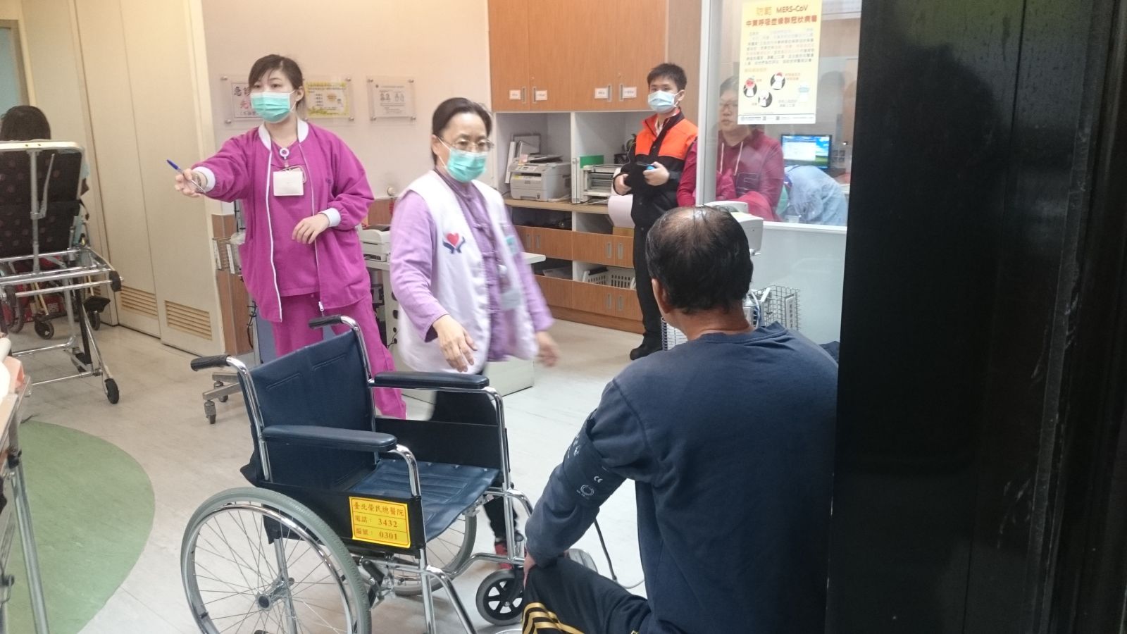 急診志工推輪椅至檢傷處，協助民眾檢查